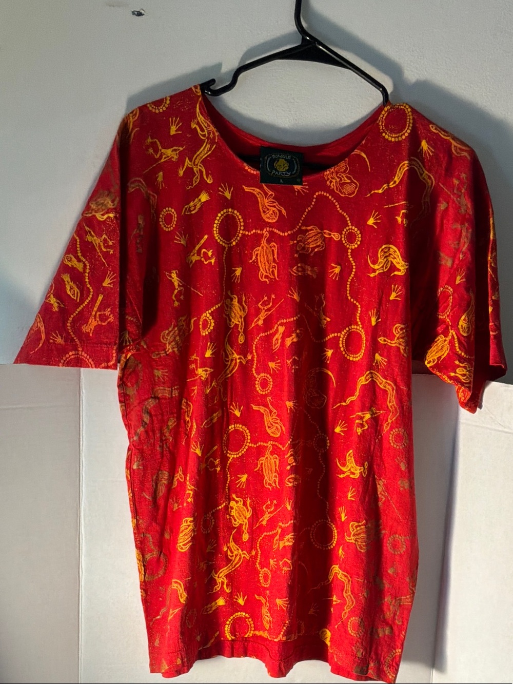 Red top features of vibrant gold all over pattern